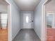 A charming entryway featuring gray plank walls, ceramic tile floors, and a white front door with decorative glass at 225 N Main St, Mount Pleasant, NC 28124