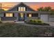 Charming gray home with a cozy front porch and well-manicured landscaping at sunset at 225 N Main St, Mount Pleasant, NC 28124