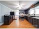 A modern kitchen features stainless steel appliances, dark cabinets, and a view into the dining room at 225 N Main St, Mount Pleasant, NC 28124