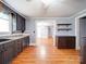 Open concept kitchen featuring grey cabinets, neutral countertops, wood floors, and built-in shelving at 225 N Main St, Mount Pleasant, NC 28124