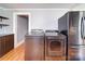 View of laundry room with gray washer and dryer next to a stainless steel refrigerator at 225 N Main St, Mount Pleasant, NC 28124