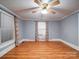 A bright living room with hardwood floors, a ceiling fan, and modern window coverings at 225 N Main St, Mount Pleasant, NC 28124