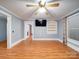 An airy living room has wood floors, a ceiling fan, and a mounted TV that enhances the entertainment space at 225 N Main St, Mount Pleasant, NC 28124