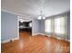 An open-concept living room has hardwood floors, classic trim, and a view into the kitchen at 225 N Main St, Mount Pleasant, NC 28124
