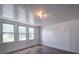 Bright room with wood flooring, three windows, and a white door at 225 N Main St, Mount Pleasant, NC 28124
