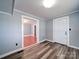 Neutral room with wood flooring, white trim, and a view into the other room at 225 N Main St, Mount Pleasant, NC 28124