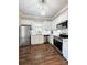 Modern kitchen with white cabinets, stainless steel appliances, and beautiful wood flooring at 229 W Gray Ave, Mooresville, NC 28115
