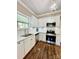 Modern kitchen featuring stainless steel appliances, quartz countertops, and beautiful hardwood floors at 229 W Gray Ave, Mooresville, NC 28115