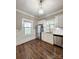 Bright kitchen features stainless appliances, white cabinetry, and wood floors at 229 W Gray Ave, Mooresville, NC 28115