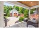 Covered outdoor area with stone flooring, wicker seating, and a view of a detached garage with a wooden door at 2304 Commonwealth Ave, Charlotte, NC 28205