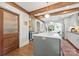 Open-concept kitchen featuring a central island with marble countertop, wooden beams, and pendant lighting at 2304 Commonwealth Ave, Charlotte, NC 28205