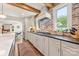 Open kitchen with brick backsplash, stainless range, white cabinets, and connection to formal dining room at 2304 Commonwealth Ave, Charlotte, NC 28205