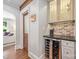 Corner wet bar with wine chiller, glass storage, and unique brick backsplash at 2304 Commonwealth Ave, Charlotte, NC 28205