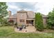 Backyard view featuring a brick patio, a fire pit surrounded by cozy chairs, and lush green landscaping at 2817 Bevis Ln, Waxhaw, NC 28173