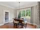 Dining room featuring wood floors, modern light fixture, bar-height dining table, and a door to the backyard at 2817 Bevis Ln, Waxhaw, NC 28173