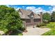 Beautiful brick home with a three-car garage, a well-manicured lawn, and lush landscaping offering curb appeal at 2817 Bevis Ln, Waxhaw, NC 28173