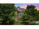 Stunning brick home with lush greenery, elegant architectural details, and a beautifully landscaped front yard at 2817 Bevis Ln, Waxhaw, NC 28173