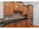 Kitchen featuring wooden cabinets, tile backsplash, granite countertops, and stainless appliances at 2817 Bevis Ln, Waxhaw, NC 28173