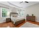 Well-lit main bedroom featuring hardwood floors, tray ceiling, a ceiling fan, and large windows at 2817 Bevis Ln, Waxhaw, NC 28173