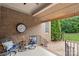 Relaxing covered brick patio featuring comfortable seating and an outdoor clock, perfect for enjoying quiet moments at 2817 Bevis Ln, Waxhaw, NC 28173