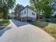 Back exterior view of brick home featuring a long driveway, yard space, and white trim accents at 300 W Thomas St, Salisbury, NC 28144