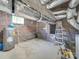 Unfinished basement featuring brick walls, water heater, exposed ductwork, and small window providing natural light at 300 W Thomas St, Salisbury, NC 28144