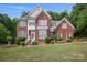 Charming brick two-story home featuring light-colored accents, pristine landscaping, and shuttered windows at 3104 Highgate Dr, Fort Mill, SC 29715