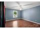 A blue bedroom features hardwood floors, black out curtains, and a ceiling fan at 3712 Eaglebrook Dr, Gastonia, NC 28056