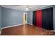 Another view of the blue bedroom featuring hardwood floors and colorful curtains at 3712 Eaglebrook Dr, Gastonia, NC 28056