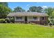 Charming home boasting a well-manicured lawn, brick accents, and a inviting front porch perfect for relaxation at 3712 Eaglebrook Dr, Gastonia, NC 28056