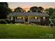 Charming ranch-style home with a brick facade, covered porch, and lush front lawn at sunset at 3712 Eaglebrook Dr, Gastonia, NC 28056