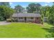 Lovely single-story home with a lush green lawn and inviting front porch nestled amongst mature trees at 3712 Eaglebrook Dr, Gastonia, NC 28056