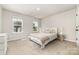 Bright bedroom featuring neutral walls, plush carpet, and two windows for natural light at 4009 Stoneygreen Ln, Charlotte, NC 28215
