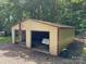 A detached two car garage with a beige exterior, red trim, and American flag hung outside at 4225 Stewart Rd, Claremont, NC 28610