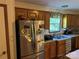Cozy kitchen featuring wood cabinets, stainless steel refrigerator, and a sink overlooking the backyard at 4225 Stewart Rd, Claremont, NC 28610