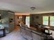 An expansive living room featuring carpet and wood flooring, comfortable seating, and natural light at 4225 Stewart Rd, Claremont, NC 28610