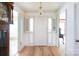Bright foyer featuring hardwood floors, a classic chandelier, and a traditional, white front door at 4234 Woodglen Ln, Charlotte, NC 28226