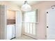 Convenient laundry room featuring a washing machine and dryer, with bright natural light and storage space at 4234 Woodglen Ln, Charlotte, NC 28226