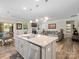 Open kitchen and living area with island, stainless steel appliances, and hardwood floors at 4316 Falls Lake Sw Dr, Concord, NC 28025