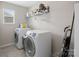The laundry room contains a large washer and dryer and storage shelves at 4316 Falls Lake Sw Dr, Concord, NC 28025