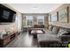 Relax in this cozy living room with a large sectional couch, TV, and plenty of natural light at 4316 Falls Lake Sw Dr, Concord, NC 28025