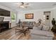 Bright living room features a cozy fireplace, ceiling fan, and wood floors at 4316 Falls Lake Sw Dr, Concord, NC 28025