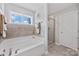 Bathroom features a soaking tub, tiled shower with glass doors, and a large window at 5384 Gatsby Cir, Rock Hill, SC 29732