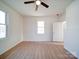 Bedroom featuring hardwood floors, a window, a ceiling fan, and a door to the side at 55 Ranlo Ave, Gastonia, NC 28054