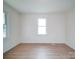 Bright bedroom with white walls, vinyl flooring and a single window at 55 Ranlo Ave, Gastonia, NC 28054