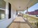 Covered front porch with wood floors, new railings and a view of the neighborhood at 55 Ranlo Ave, Gastonia, NC 28054
