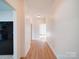 Long hallway leading to an open space and featuring new hardwood flooring at 55 Ranlo Ave, Gastonia, NC 28054