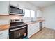 Bright kitchen featuring white cabinets, butcher block countertops, and stainless appliances at 55 Ranlo Ave, Gastonia, NC 28054