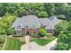 Stunning aerial view of a brick home with lush landscaping, mature trees, and an inviting entrance at 5701 Challisford Ln, Charlotte, NC 28226