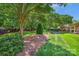 Serene backyard featuring lush greenery, mature trees, and meticulously maintained landscaping at 5701 Challisford Ln, Charlotte, NC 28226